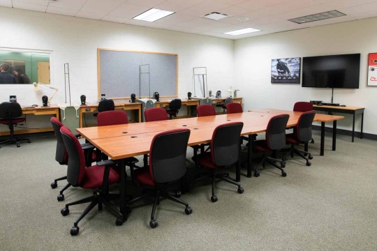 Seminar room with a large conference table facing a large TV screen