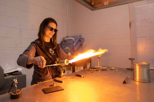 Student igniting a torch to heat metal