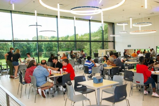 students sitting in Gracie's dining room, eating together.