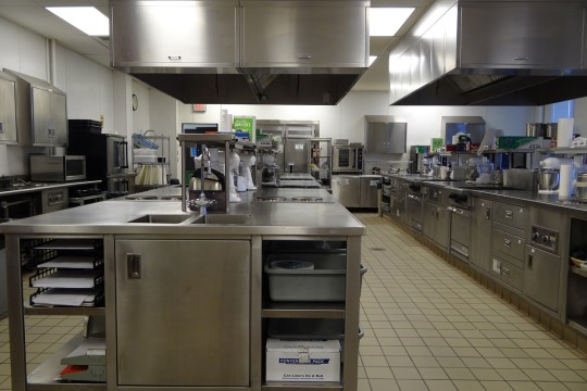 Professional kitchen setup with stainless steel appliances and cooktops