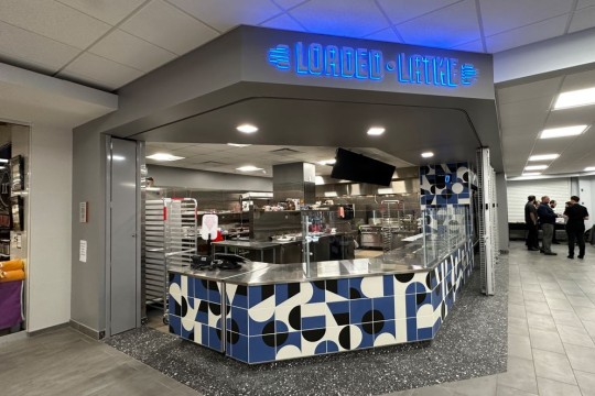 Loaded Latke sign lit up with kitchen and ordering counter below it 