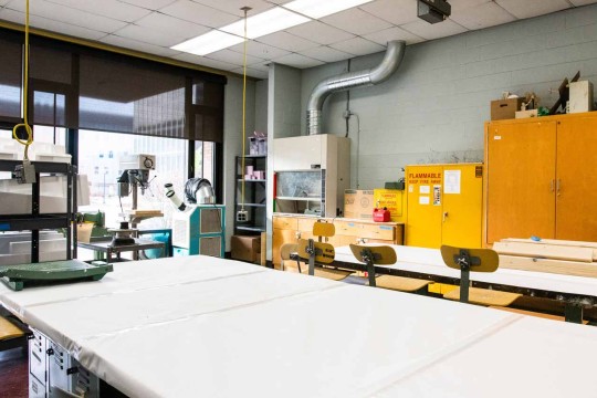 Metal working station with cabinets in against a wall