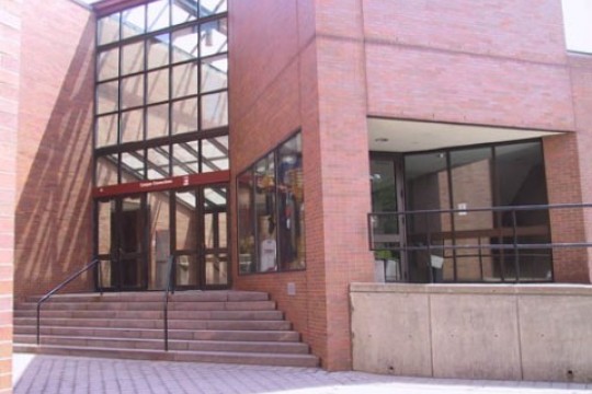 the exterior of a brick building, with steps leading to the entrance.