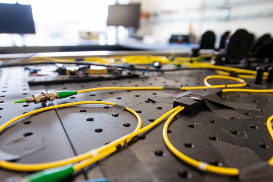 Series of cables attached to a black board with tape