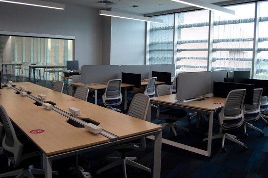 a lab with several workstations and a long table with outlets.