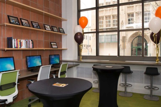 Room with green carpet and a large window with balloons on either side