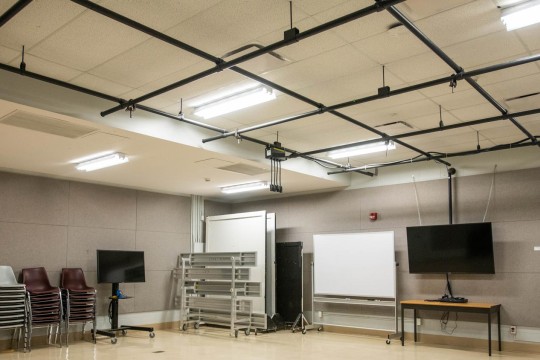 Empty sound room with sound proofing on the walls and tracks hanging from the ceiling