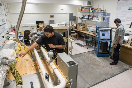 Workers calibrating a machine before running a test
