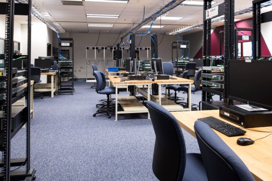 a lab with computers, racks, switches, routers and servers.