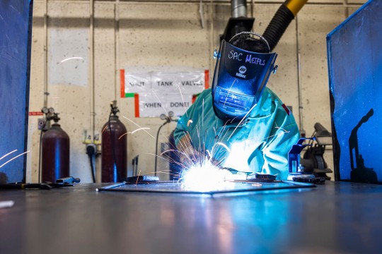 a student wears protective gear while welding.