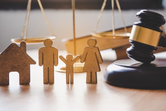 wooden cutout figures of a family with scales of justice and judges gavel