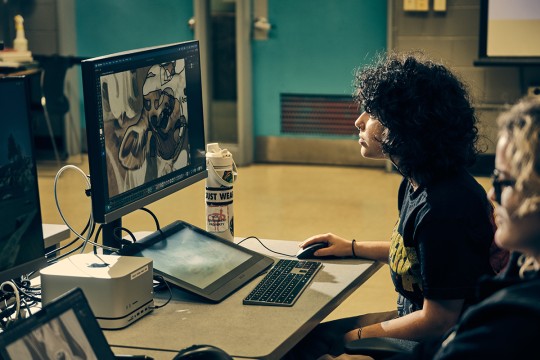 An RIT illustration student works at a computer station.