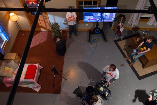 overhead view of the soundstage, which is set up like a bedroom, with several students working with cameras and props.
