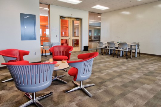 Lounge space with chairs and white board wall.