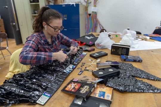 A student makes a wearable sculpture from Star Wars V H S tape.