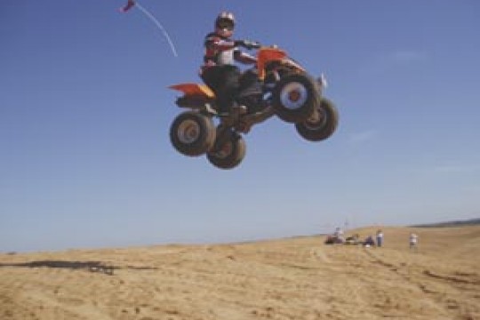 Student testing ATV in sand dunes