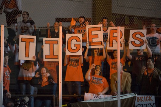 People holding signs with letters on them