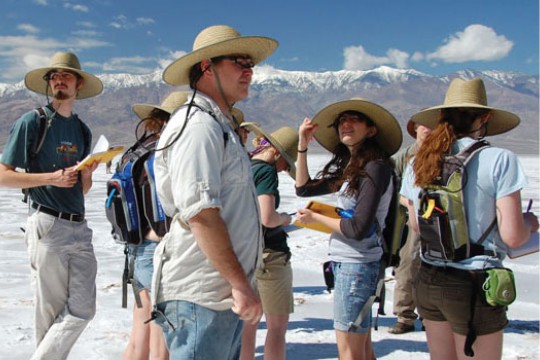 Students taking notes near mountains