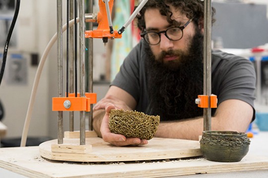 Student uses 3D ceramic printer.
