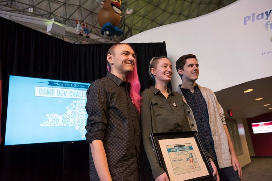 Three students holding the Game Dev Challenge award certificate.