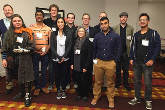 A group of RIT faculty and students stand and pose for a photo.