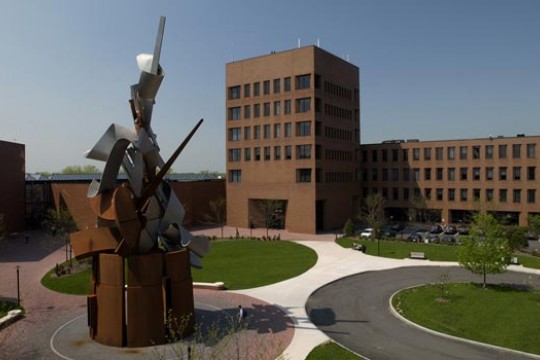 Picture of large statue in front of brick buildings
