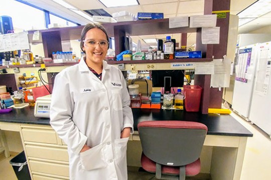 Portrait of Ashley Adair in a lab wearing a white coat and glasses.