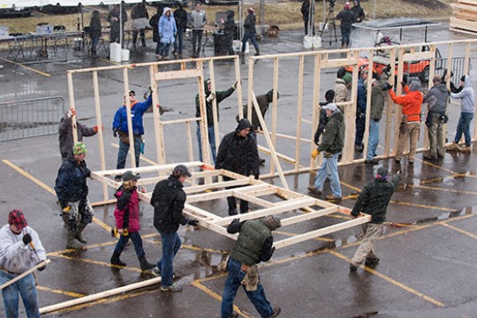 volunteers building framing for a house.