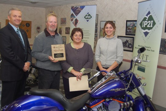 People posing with award behind motorcycle