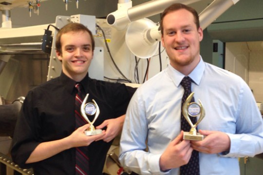 Two people posing with awards in lab