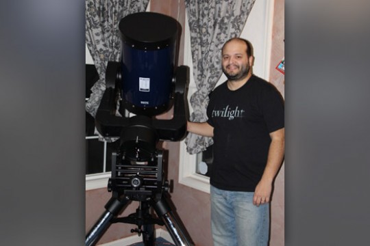 Person posing with giant telescope.