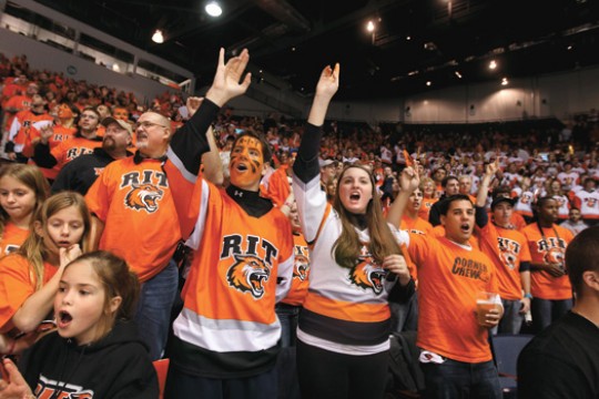 Crowd of people at hockey game wearing RIT Jerseys.