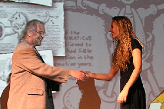 Two people shaking hands on stage