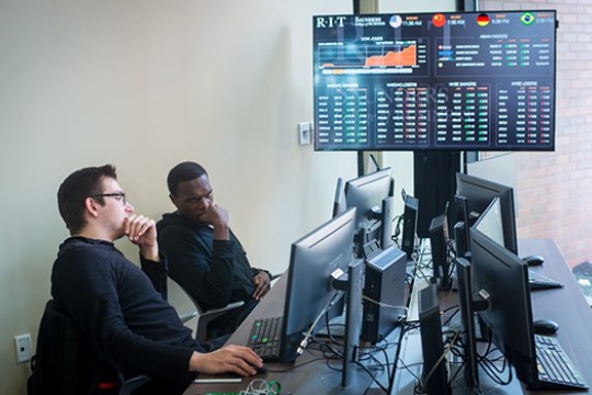 two people looking thoughtful at computer screens.