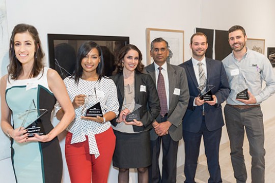 Award winners line up for a photo holding trophies.