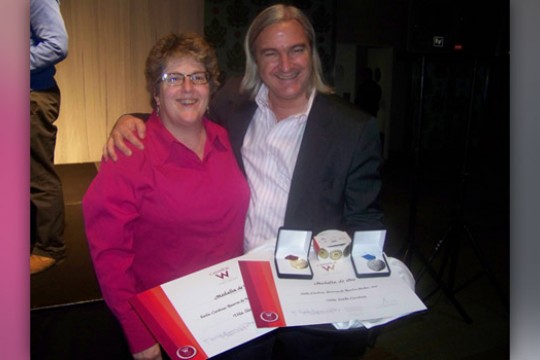Two people posing with award