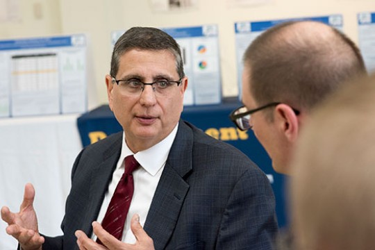 Michael Ciminelli talks with another man, using his hands to emphasize his point.