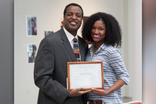 Two people posing with award