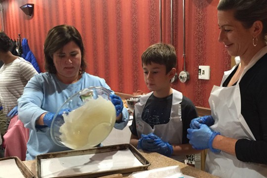 woman pouring dough into a baking sheet.