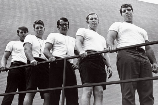 black and white photo of a group lined up against a railing.