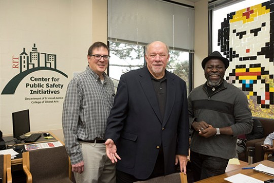Three people standing in the Center for Public Safety Initiatives office.