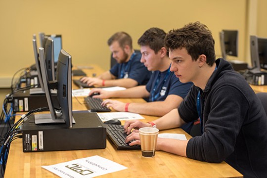Three people focused on computer screens.