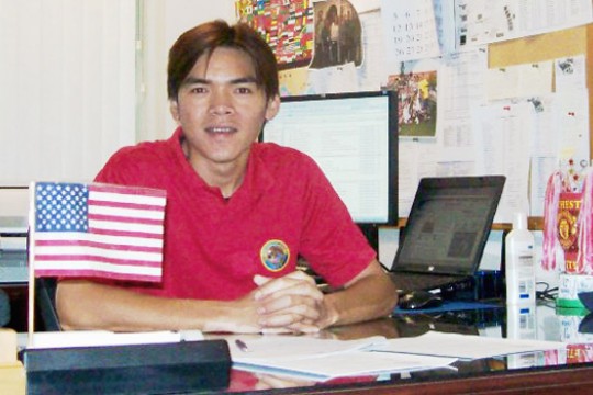Person sitting at desk next to American flag