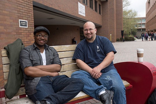 Two people posing together on bench