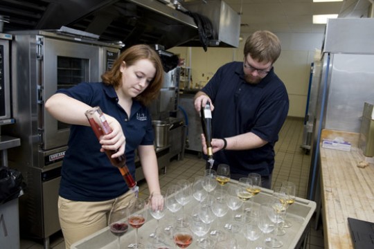 People pouring liquid into glasses