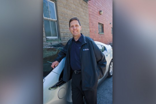 Person posing next to car