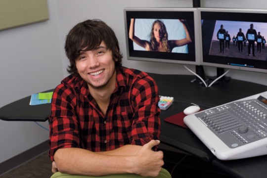 Student posing in front of computers