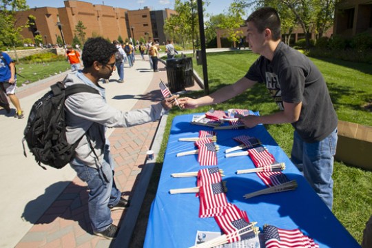 Person handing out flags on walkway