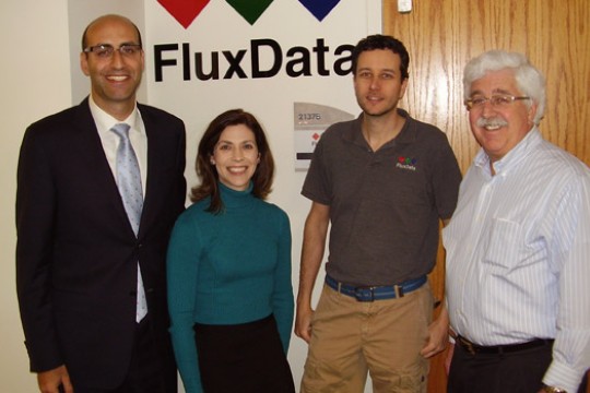 People posing in front of "Flux Data" logo
