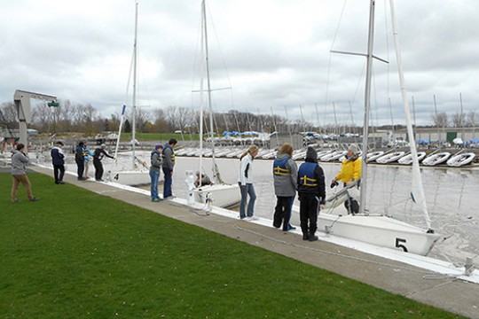 People rigging sailboats